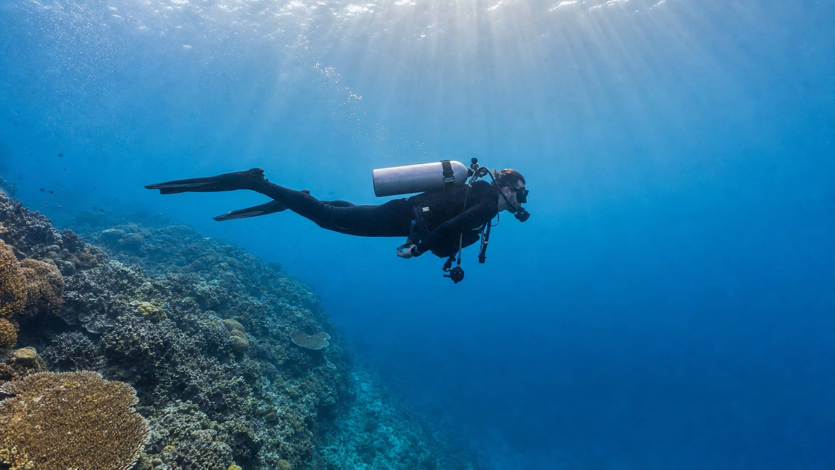 Taucher im 3-mm-Neoprenanzug im klaren warmen Wasser vor Balis Nordostküste